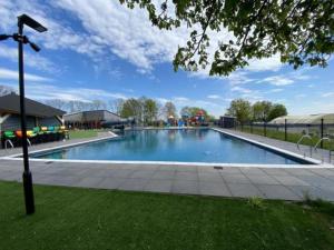 a large swimming pool in the middle of a park at Moderne chalet met hottub in Lathum