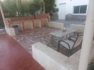 a patio with a table and some chairs and a table at إستراحة الريف in Kalbā