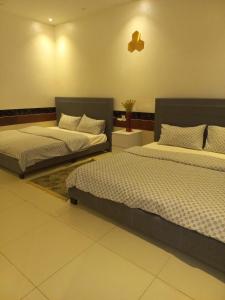 two beds sitting in a room with at إستراحة الريف in Kalbā +10 photos