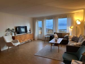 a living room with a couch and a tv at Aurora Hav og Fjell feriehus Vannøya in Karlsøy