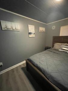 een slaapkamer met een bed en wat foto's aan de muur bij Lake House Hide Away in Roxboro