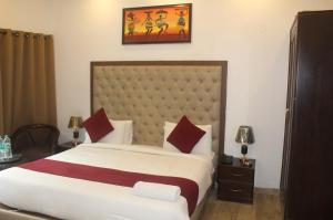ein Schlafzimmer mit einem großen weißen Bett mit roten Kissen in der Unterkunft Khanna Residency in Neu-Delhi + 27 Fotos