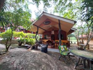 a building with a pavilion with tables and chairs at Bamboo River House Kaengkrachan in Ban Nong Chaeng