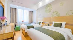 a hotel room with two beds and a desk at GreenTree Inn Shanghai Jingan Railway Station Xinzha Road Business Hotel in Shanghai +197 photos