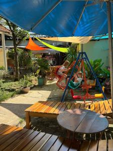 ein Spielplatz mit Tisch und Schaukel in der Unterkunft Cao Nguyên Bungalow in Phu Quoc