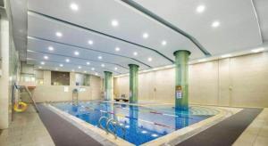 a large swimming pool in a large building at New Century Hotel Nanjing in Pukou