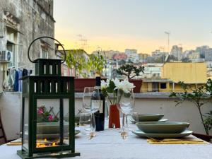 a table with plates and glasses and a bottle of wine at Diso apartments in Naples