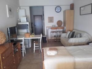 a living room with a bed and a table and a kitchen at Property Direct Stadem Apartment Second Floor in Larnaca
