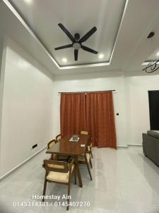 a dining room with a table and a ceiling fan at Homestay Ain in Kuala Terengganu