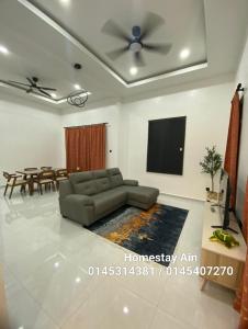 a living room with a couch and a flat screen tv at Homestay Ain in Kuala Terengganu
