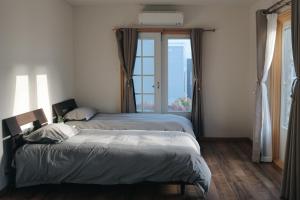 twee bedden in een kamer met een raam bij sakurayuki in Otaru