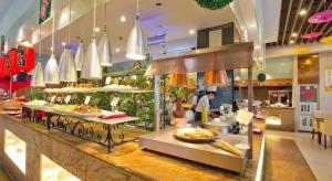 a buffet line in a restaurant with food on display at Inzone Garlnd Hotel Zhangqiu in Zhangqiu
