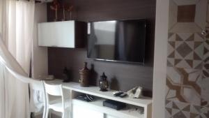 Habitación con mesa blanca y TV en la pared. en Lindo Apartamento à Beira Mar, en João Pessoa