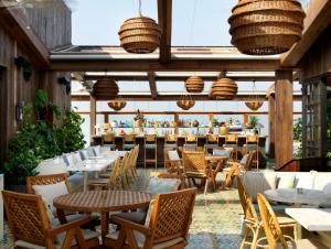 a restaurant with tables and chairs and a bar at Soho House Mumbai in Mumbai