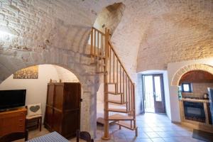 a staircase in a room with a stone wall at Dimora Conte, Alberobello in Alberobello +10 photos