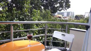 a glass of wine sitting on a table on a balcony at Balkony 407 - Três quartos Perto UNB in Brasilia