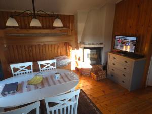 a living room with a table and a television and a fireplace at Backamgården in Sälen