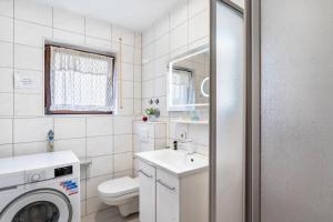 a bathroom with a toilet sink and a washing machine at Alb-Rosa in Bad Herrenalb +41 photos
