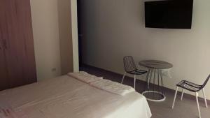 a bedroom with a bed and a table and chairs at Hotel Vallehermoso Lunahuana in Lunahuaná