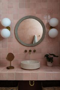 a pink tiled bathroom with a sink and a mirror at Stylish, Spa, Cowboy Pool Flamingo Social Club in Yucca Valley