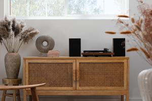 a room with a wooden cabinet with vases and a window at Stylish, Spa, Cowboy Pool Flamingo Social Club in Yucca Valley