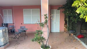 Una casa rosa con una mesa y sillas delante de ella. en La Casetta rosa, en Diano Marina 3 fotos más