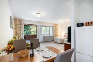 a kitchen and living room with a table and a refrigerator at Alb-Rosa in Bad Herrenalb
