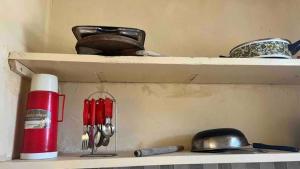 a shelf with bowls and utensils on it at Armaan Enclave Diani in Diani Beach +29 photos