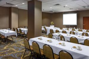 ein Konferenzraum mit Tischen, Stühlen und einer Leinwand in der Unterkunft Radisson Hotel Bismarck in Bismarck + 37 Fotos