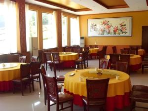 a dining room with yellow tables and chairs and windows at GreenTree Inn Laiwu Frank in Zhaizi