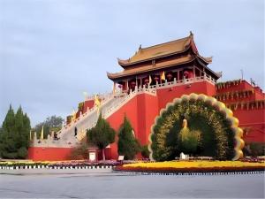Un edificio rojo con un gran árbol al frente. en James Joyce Coffetel·Kaifeng Drum Tower, en Kaifeng