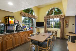 a kitchen with a table and chairs and two windows at Days Inn by Wyndham Fremont in Fremont