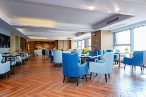 a dining room with blue chairs and tables at Echarm Hotel Xiantao Yuantai Weilaicheng in Xiantao