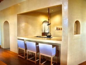 a kitchen with a bar with four white chairs at TOKI Resort HAKONE BETTEI in Hakone +17 photos