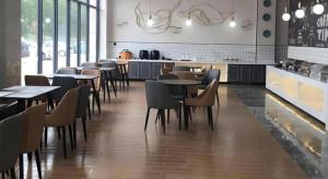 LaixiにあるGreenTree Inn Express Qingdao Laixi High-Speed Railway Station Shenzhen Roadの部屋にテーブルと椅子があるレストラン