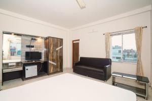 マンダーマニにあるBlooming Star Guest Houseのベッドとソファとテレビのある寝室