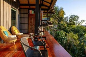 a porch with chairs and a table on a house at Flower hill 180 in Chiang Rai