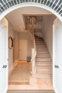 un escalier en colimaçon dans une maison avec une arche dans l'établissement De Pagode - A Serene Coastal Home with Pool, à Duinbergen