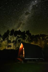 a lit up tent in a field at night at Wetland View Park in Anatori