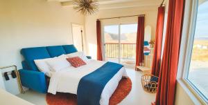 Un dormitorio con una cama azul y un balcón. en 5-Acres, Game Room, Views, Spa Starship Aurora, en Yucca Valley