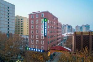 BazhouにあるGreenTree Inn Hebei Langfang Bazhou Railway Station West Yingbin Road Express Hotelの赤レンガの高い建物