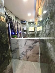 a bathroom with a shower with a marble wall at Hotel Banwari Palace in Ujjain +47 photos