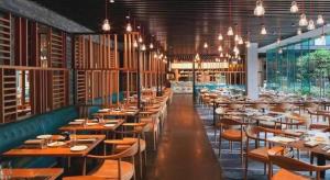 a dining room with tables and chairs and lights at 7 Days Inn Hami Baofeng Market in Qumul