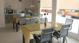 a dining room with tables and chairs and a vase with flowers at 7 Days Premium Haiyan New Bridge South Road Branch in Haiyan
