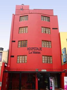 a red building with the words hostelale la vaza at Hospedaje La Videna in Lima
