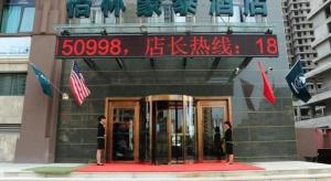 two people standing in front of a building at GreenTree Inn LangFang YanJiao Tianyang Plaza Express Hotel in Gaolou
