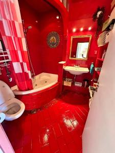 a red bathroom with a tub and a sink at Homestay Room in Utrecht