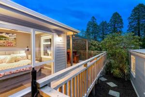 a house with a balcony with a bed on a deck at Quiet home with modern touch in Dunedin