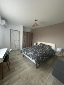 a bedroom with a bed and a desk and a desk at Maisonnette 2 à 4 personnes 