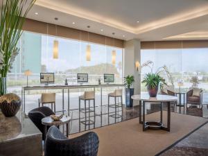 a lobby with a bar with chairs and tables at Seda Atria in Iloilo City